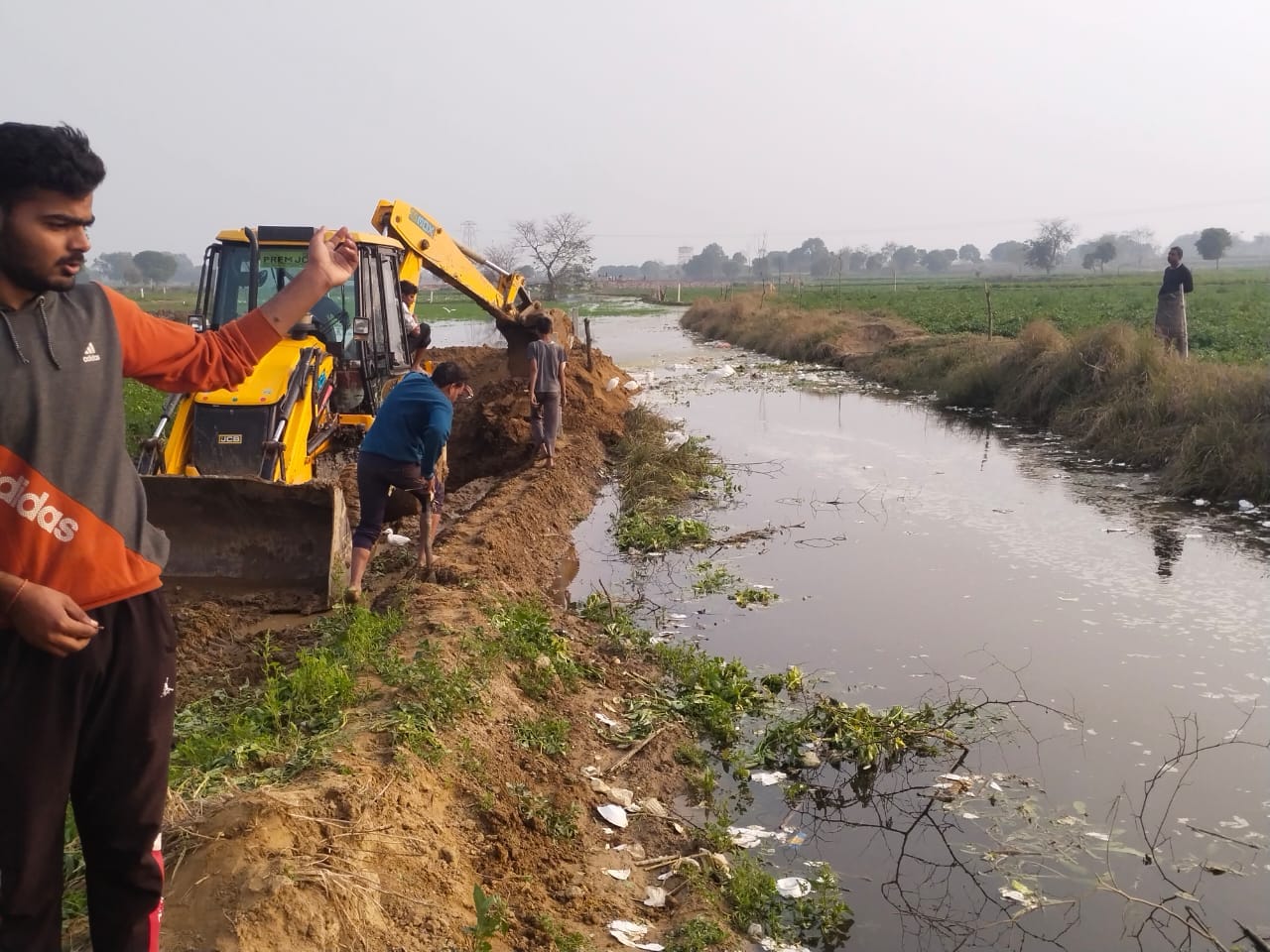 निबोहरा क्षेत्र में नाले के पानी को जेसीबी से रुकवाते किसान,खेतों में भरा पानी