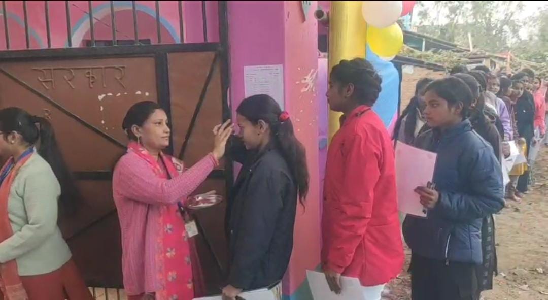 आदर्श परीक्षा केंद्र पर परीक्षार्थी को तिलक लगाते