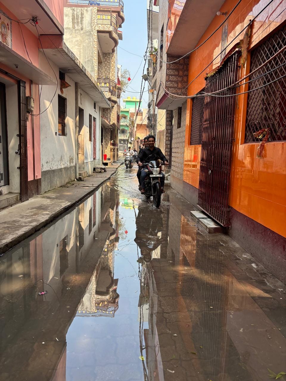 गंदे पानी के बीच से होकर गैस भरने जा रहा युवक और गलियों में भरा पानी