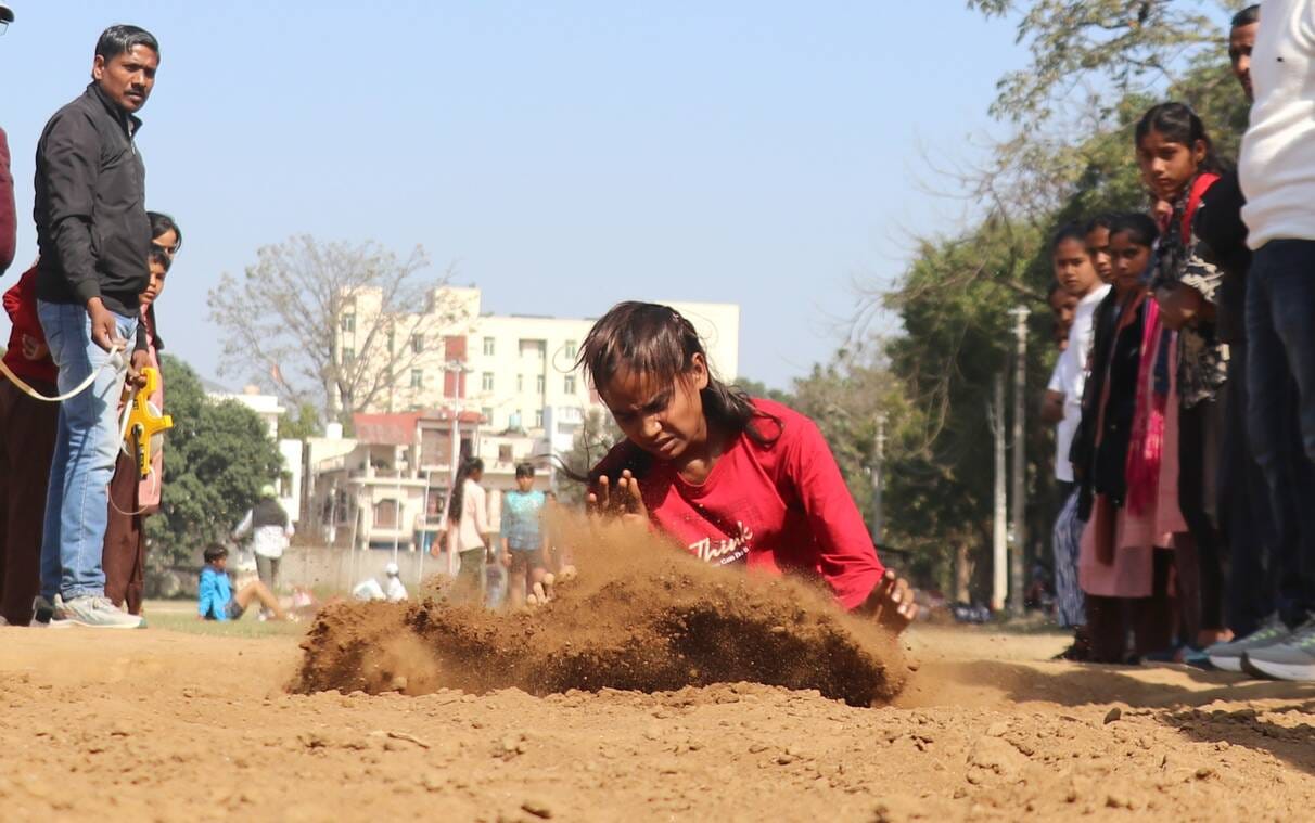 बिजनौर के नेहरू स्टेडियम में परिषदीय स्कूलों की जिला स्तरीय खेलकूद प्रतियोगिता लंबी कूद में भाग
