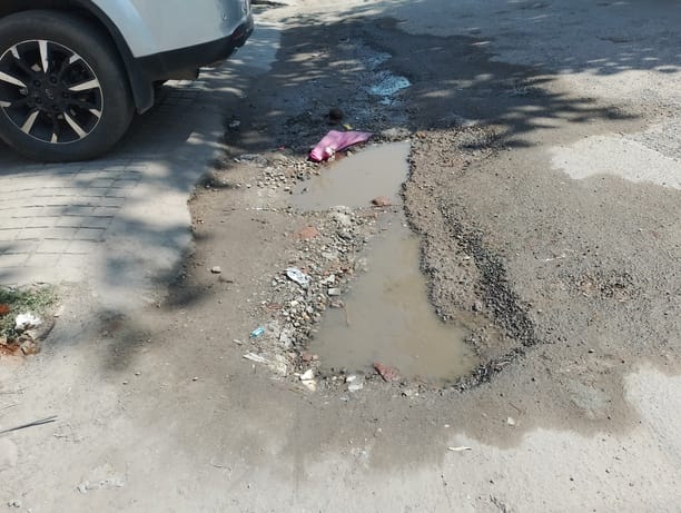 असंध रोड पर मंदिर के सामने बने गहरे गड्ढे। संवाद असंध रोड पर मंदिर के सामने बने गहरे गड्ढे। संवाद