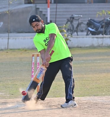 एससीपीएम कॉलेज में शॉट लगाता खिलाड़ी और मैच देखतीं छात्राएं।