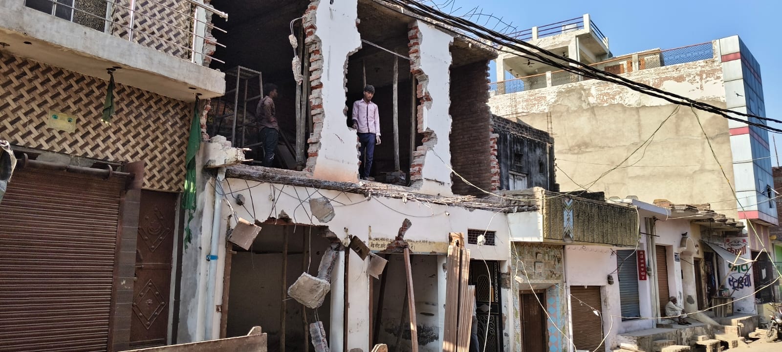 फोटो-14 कंपिल में सामूहिक दुष्कर्म के आरोपी के रिश्तेदार के घर के छज्जे को तोड़ती जेसीबी। संवाद