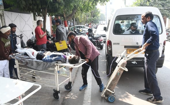 जांच के लिए मरीज को लेकर जाते लोग।