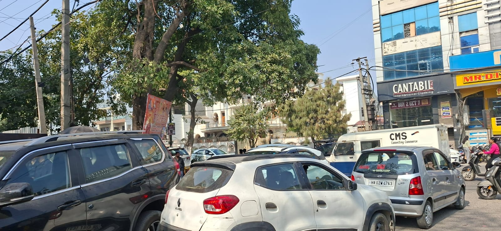 गोबिंदपुरी रोड पर लगे जाम में फंसी स्कूल की बस। संवाद