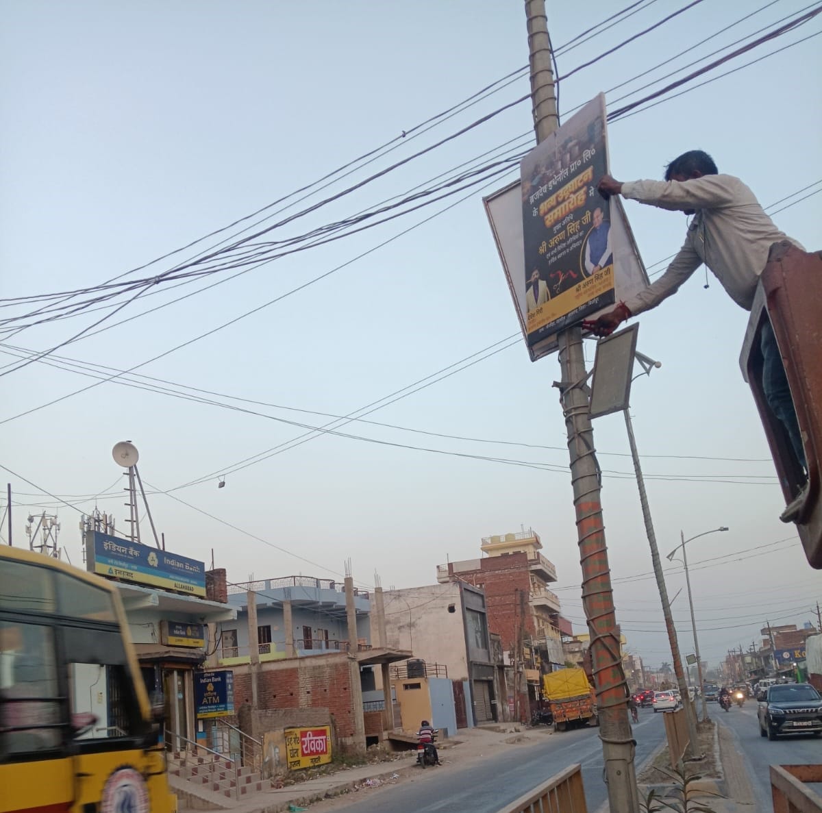 नटवां में बिजली के पोल से होर्डिंग्स उतारते नगर पालिका कर्मचारी, स्रोत संवाद