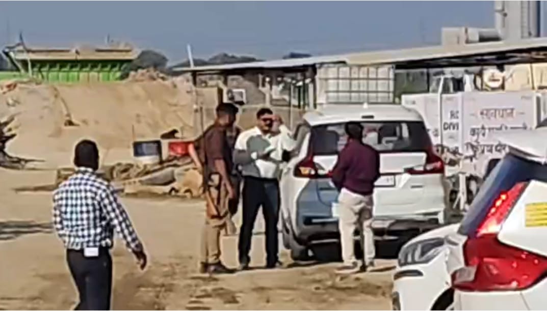 प्लांट में छापेमारी के दौरान बैरियर के पास बैठे पुलिस कर्मी- संवाद प्लांट में छापेमारी के दौरान बैरियर के पास बैठे पुलिस कर्मी- संवाद