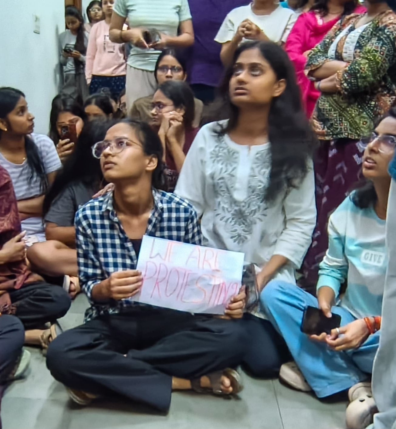 धरने पर बैठीं गंगा हॉस्टल की छात्राएं। 