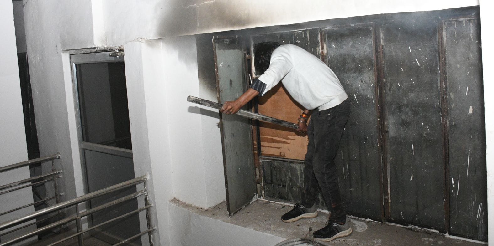 विश्वासखंड स्थित आईजी स्टांप के दफ्तर से निकलतीं लपटें और खिड़की तोड़कर आग बुझाते दमकल कर्मी।