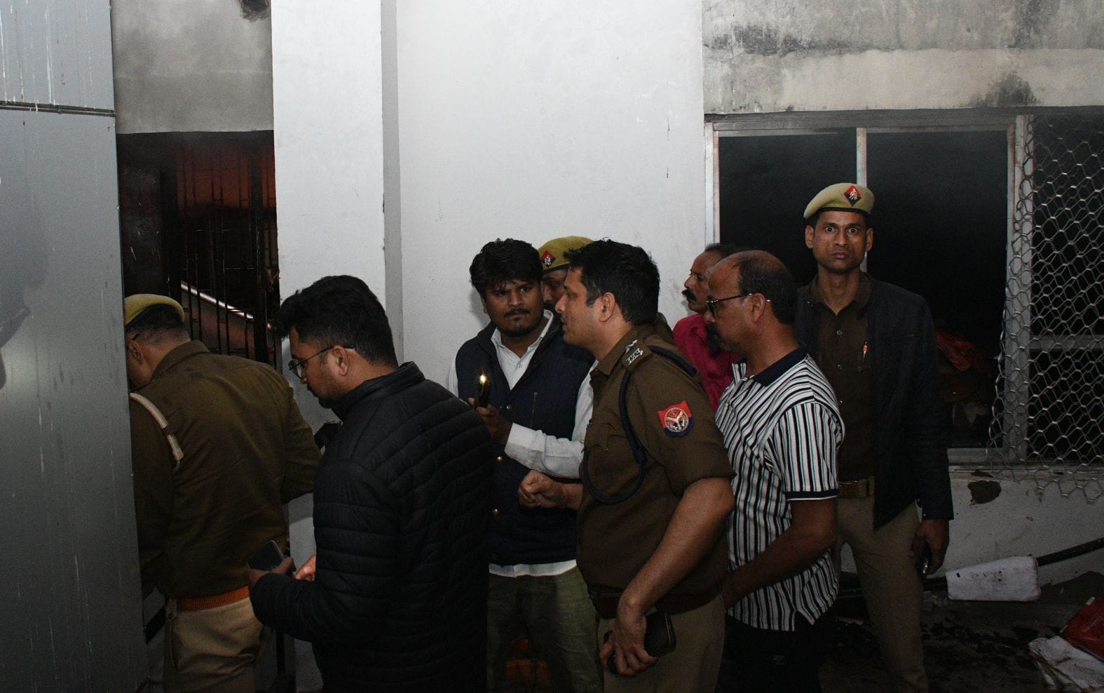 विश्वासखंड स्थित आईजी स्टांप के दफ्तर से निकलतीं लपटें और खिड़की तोड़कर आग बुझाते दमकल कर्मी।