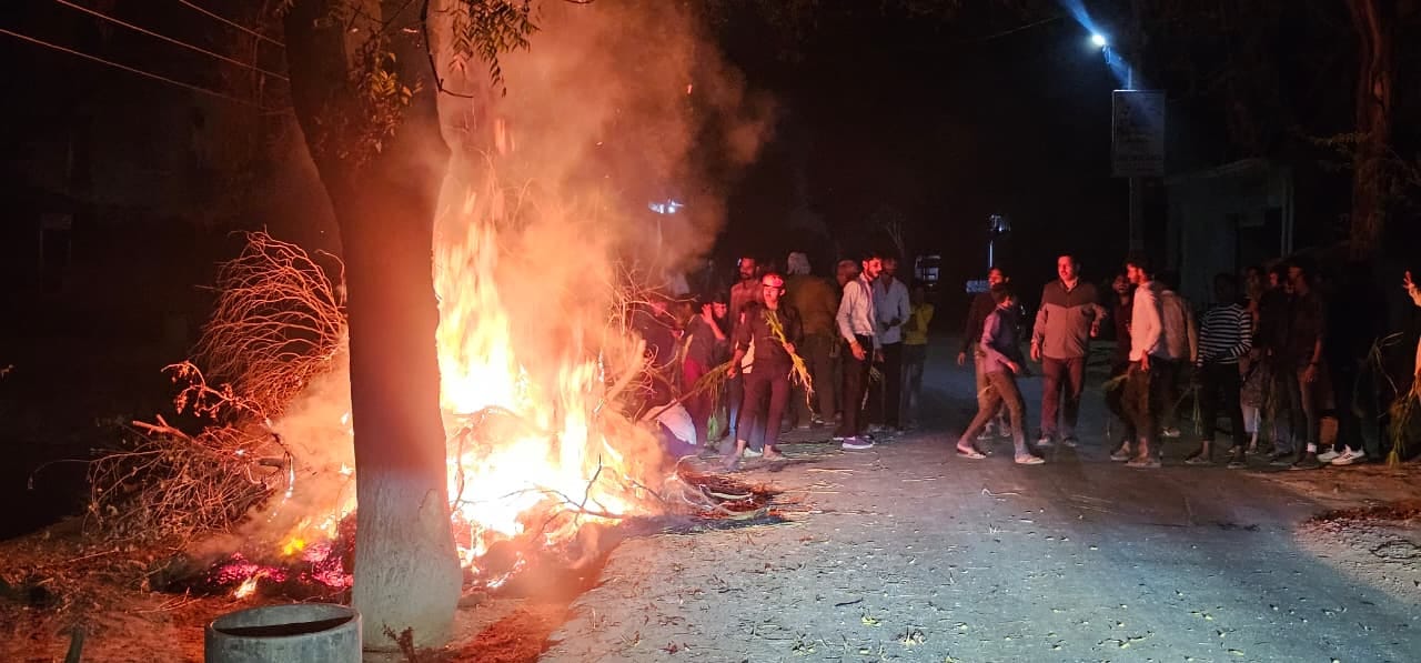 कस्बा राजा का रामपुर में होलिका पूजन करते लोग। संवाद कस्बा राजा का रामपुर में होलिका पूजन करते लोग। संवाद