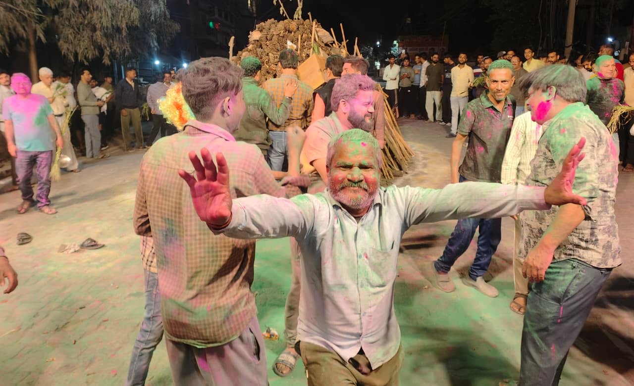 सोमवार रात गोला रोड पर कृष्णा टॉकीज के सामने होलिका दहन कार्यक्रम के दौरान रंग गुलाल उड़ाते लोग