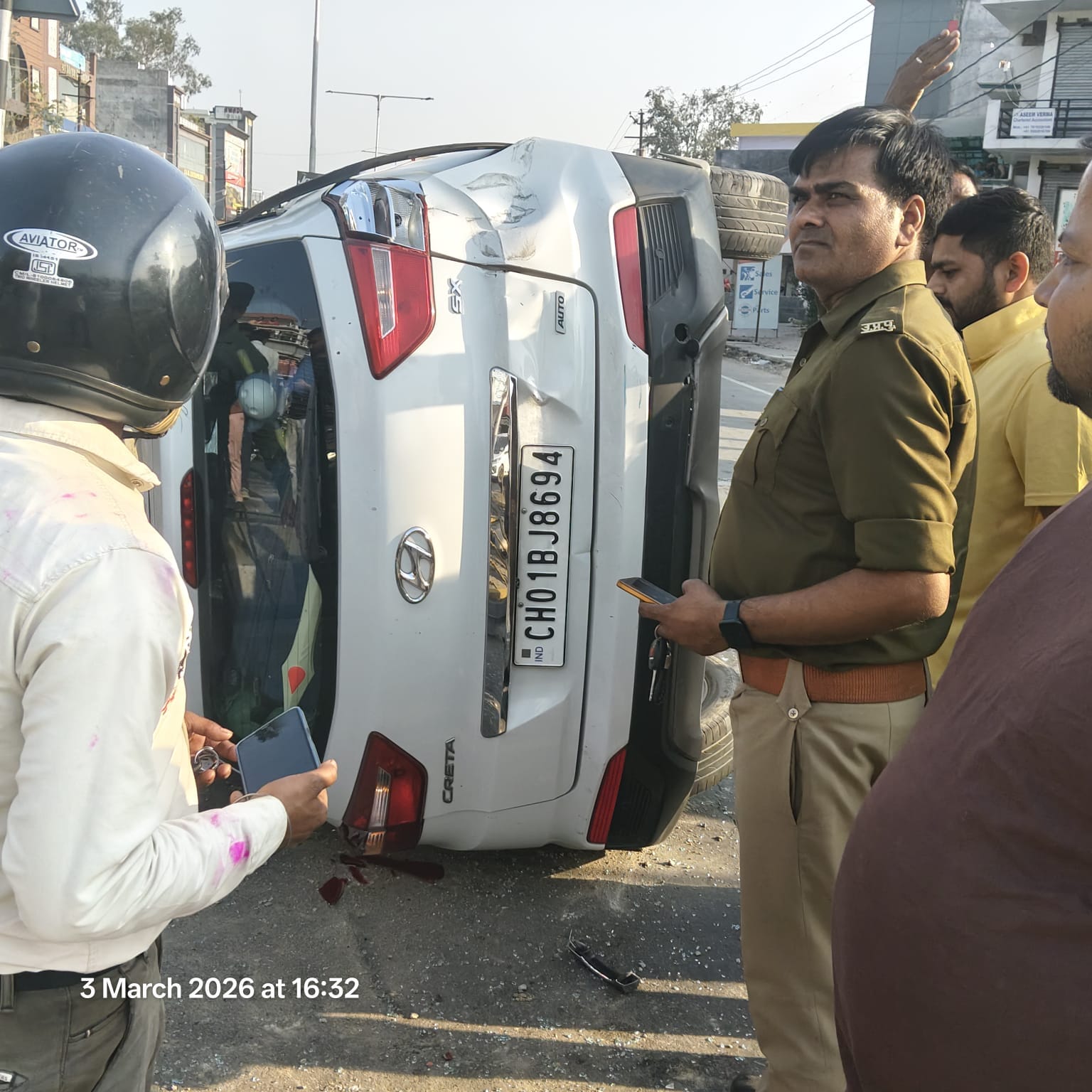 फलवरिया मोड़ के पास लखनऊ-प्रयागराज हाईवे पर पलटी कार व मौजूद लोग और पुलिस। हादसे में घायल दंपती