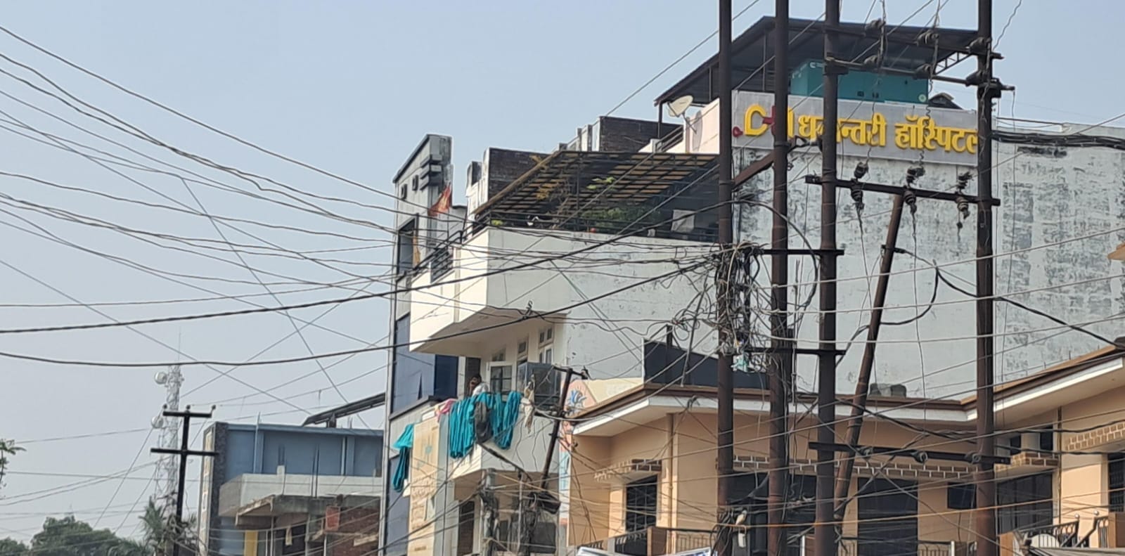 शहर के दूधिया मंदिर मार्ग लगा झुका खंभा व गली में झूलता तार। संवाद