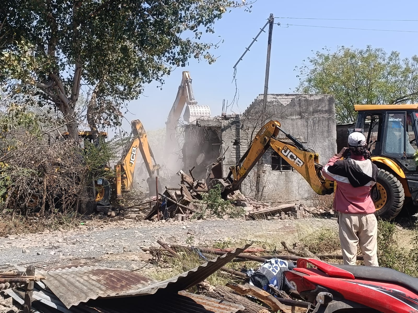 पोकलेन से मकान तोड़ते हुए पोकलेन से मकान तोड़ते हुए