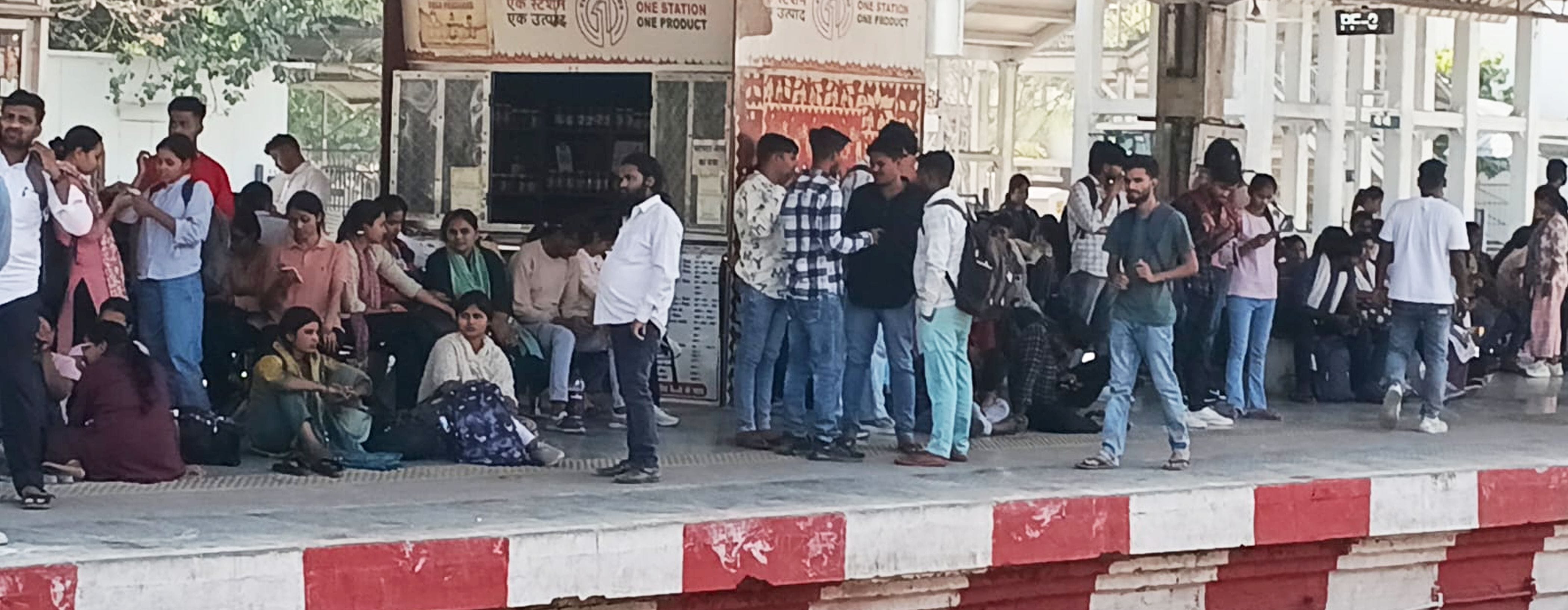 फोटो-02-रविवार की दोपहर रेलवे स्टेशन के प्लेटफार्म नंबर दो पर ट्रेन का इंतजार करते परीक्षार्थी।