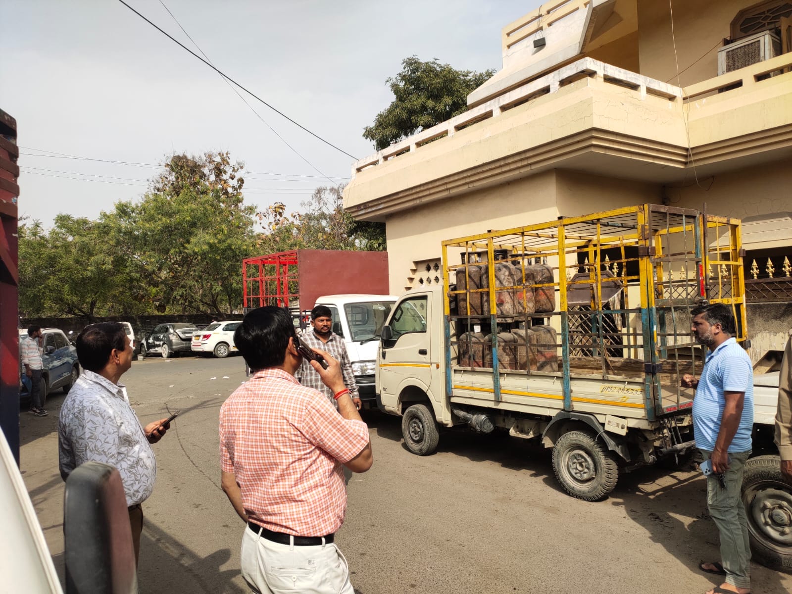 गैराज से बरामद सिलिंडर के साथ अधिकारी। 