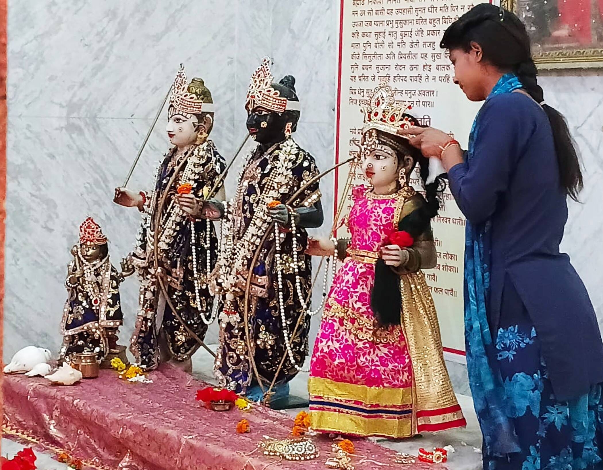 फोटो-19-कालिका जी मंदिर में स्थापित मूर्तियों का श्रृगार करती युवती। संवाद