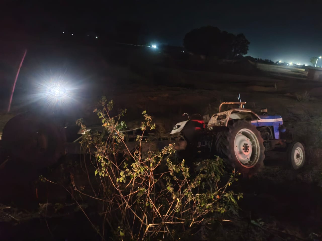 घटनास्थल पर दुर्घटनाग्रस्त कार और सड़क किनारे पलटा हुआ ट्रैक्टर