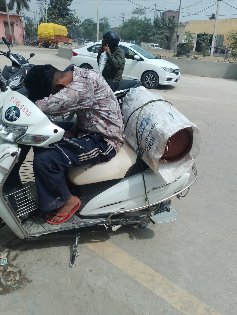 सिलिंडर लेकर जाते एक युवक।