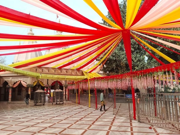 देवी मंदिर में फूलों से दरबार को सजाते कलाकार। संवाद