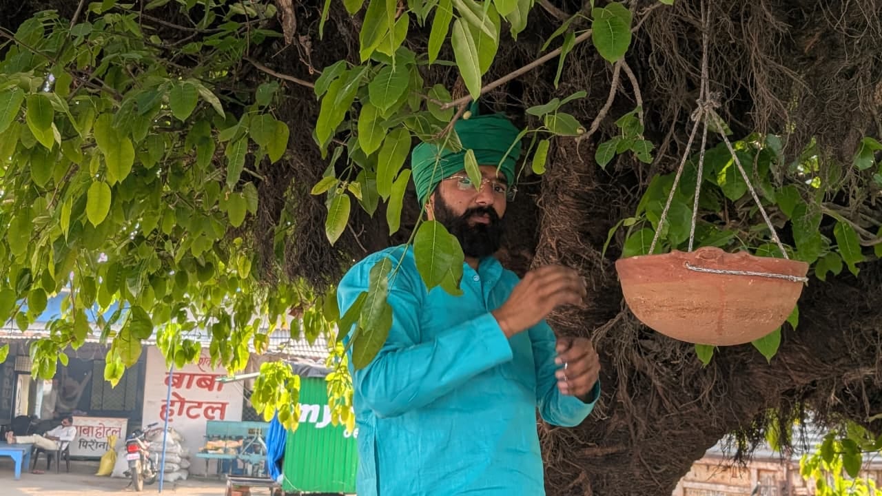 फोटो - 08 विलुप्त होती गौरैया को बचाने के लिए लोगों को घौसला देते शिक्षक अजय कुमार। संवाद