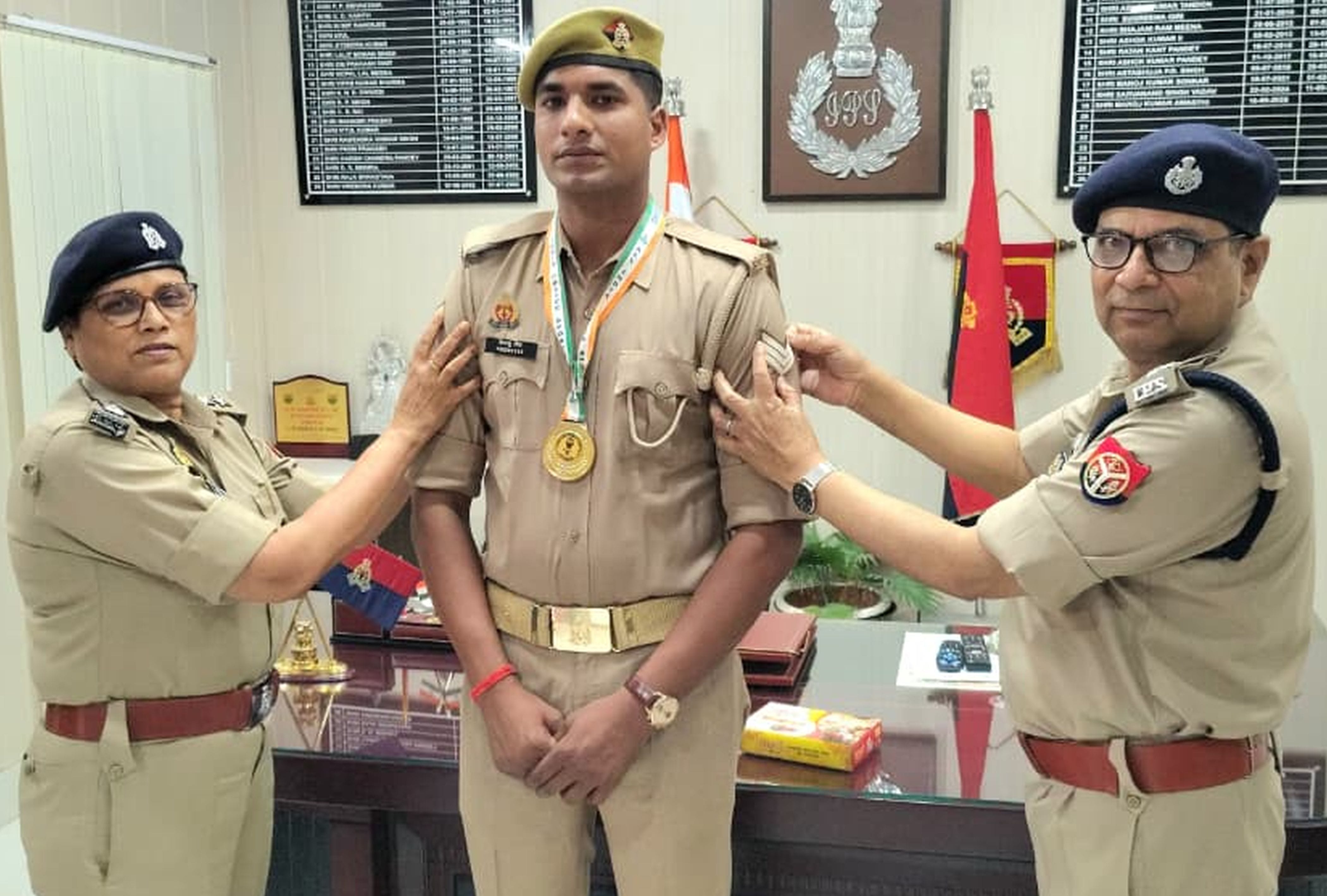 फोटो-30-आरक्षी से प्रधान आरक्षी बने हिमांशु सिंह को मेडल एवं फीती पहनाते अधिकारी। स्रोत स्वयं