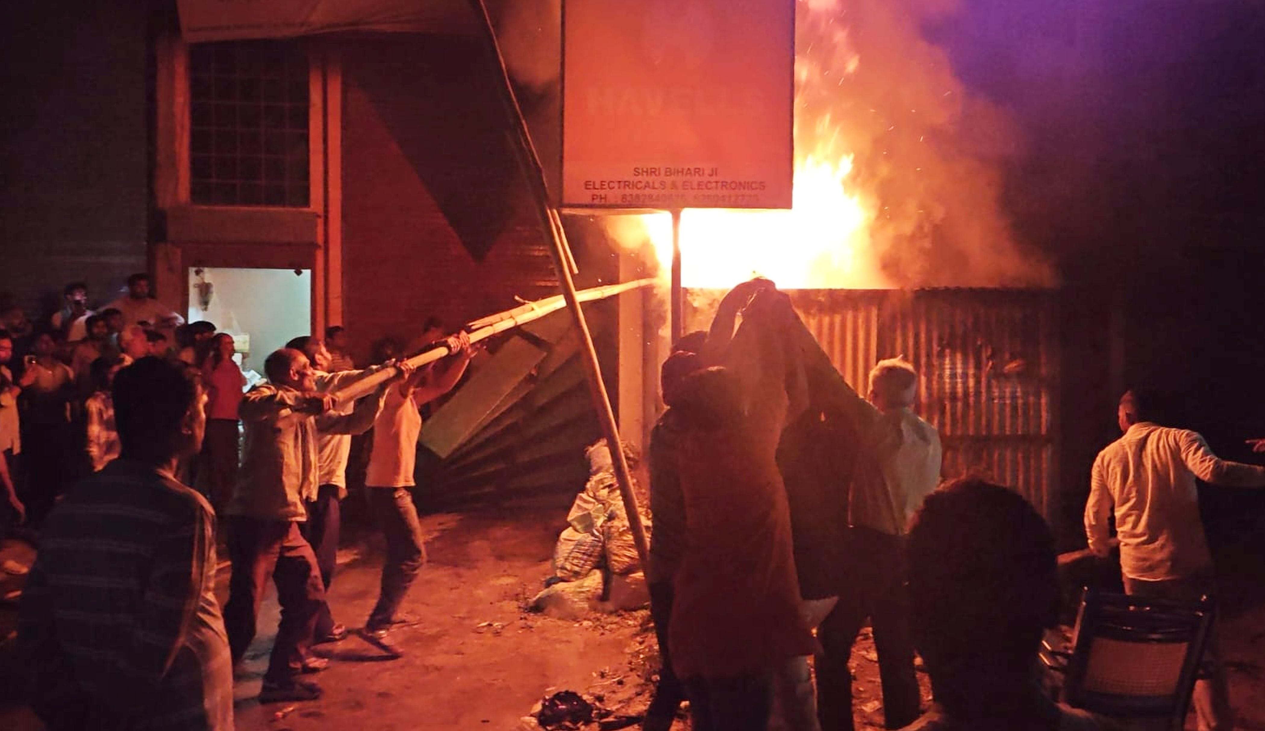 फोटो-33-आग बुझाता दमकल कर्मी व लोग। संवाद