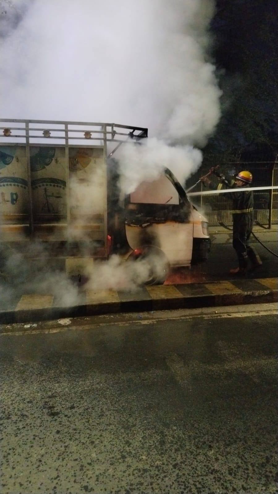 वाहन में लगी आग बुझाते दमकल कर्मी। वाहन में लगी आग बुझाते दमकल कर्मी।