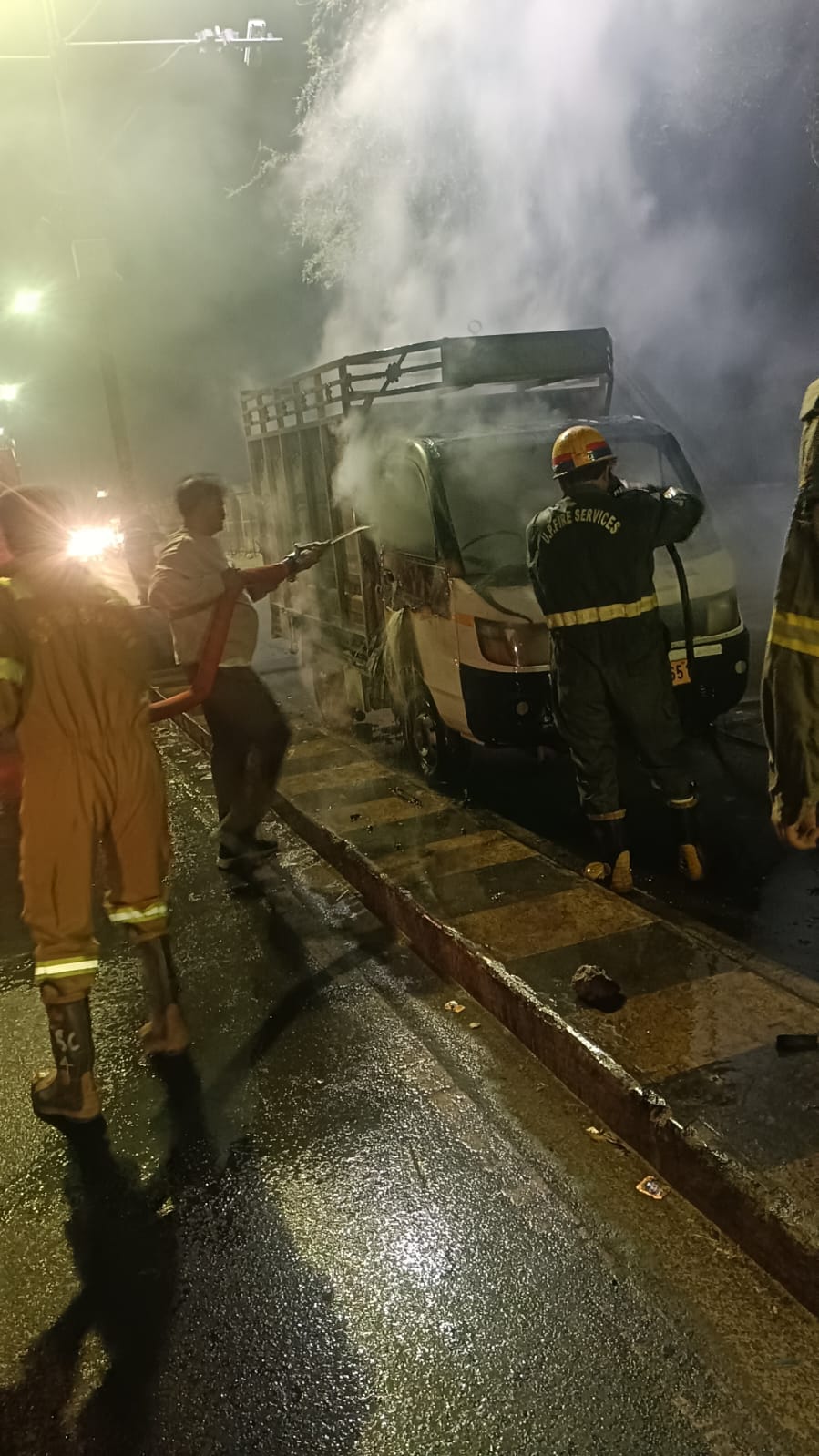 वाहन में लगी आग बुझाते दमकल कर्मी। वाहन में लगी आग बुझाते दमकल कर्मी।