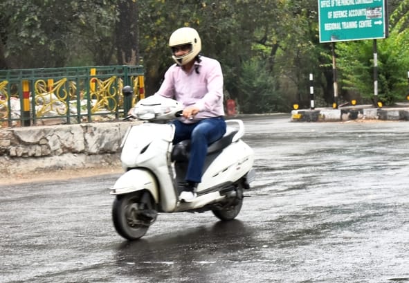 बारिश के दौरान गुजरते लोग।