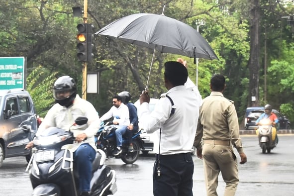 बारिश के दौरान गुजरते लोग।