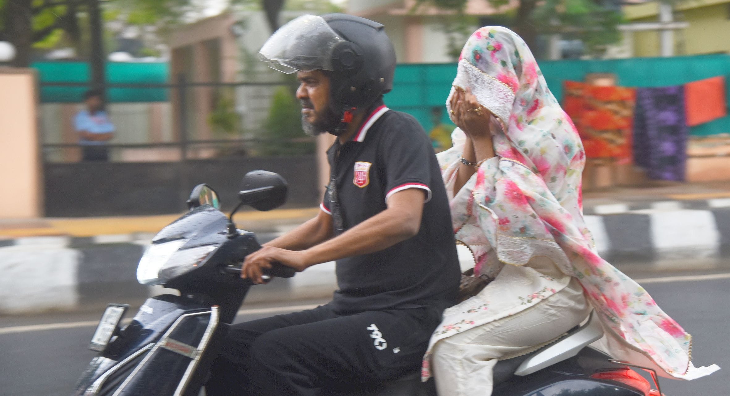 बारिश के दौरान गुजरते लोग।