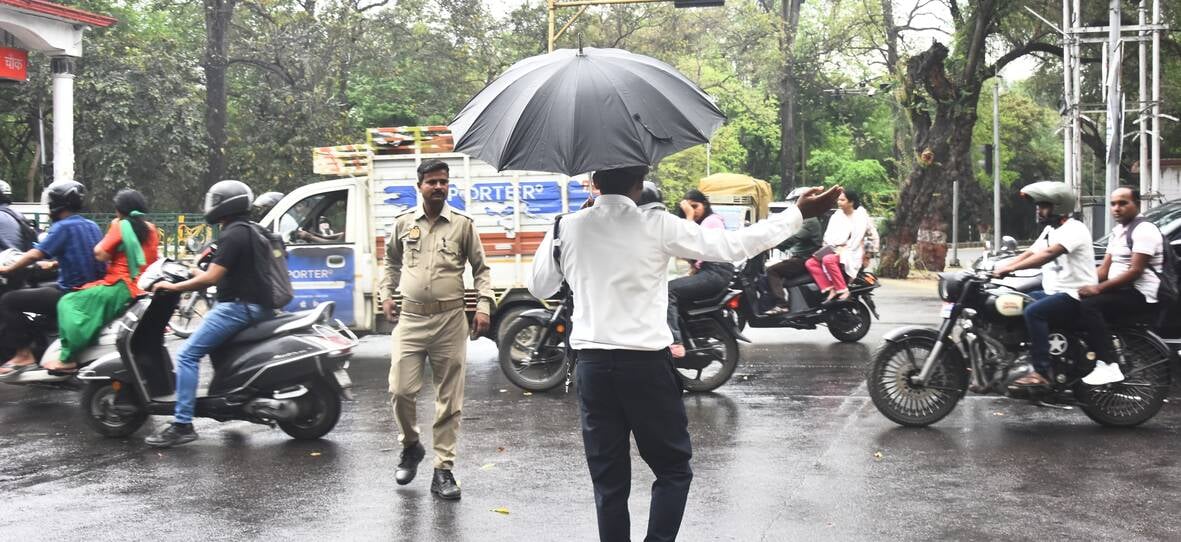 बारिश के दौरान गुजरते लोग।
