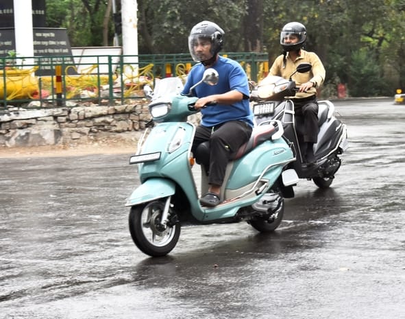 बारिश के दौरान गुजरते लोग।