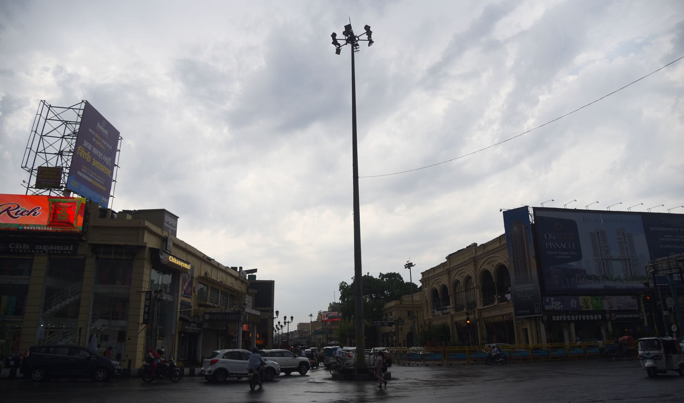 बारिश के दौरान गुजरते लोग।