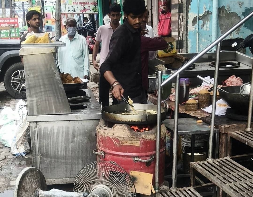 सिकंदर गेट पर गैस सिलिंडर न मिलने के कारण होटल पर लकड़ी जलाकर चूल्हें पर खाना बनाते युवक।संवाद