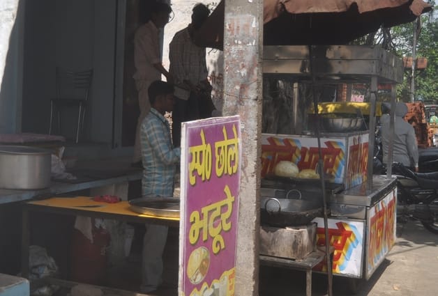 अपना घर कालोनी में गैस सिलिंडर लेने के लिए धूप में सिलिंडर पर बैठी महिला। संवाद अपना घर कालोनी में गैस सिलिंडर लेने के लिए धूप में सिलिंडर पर बैठी महिला। संवाद