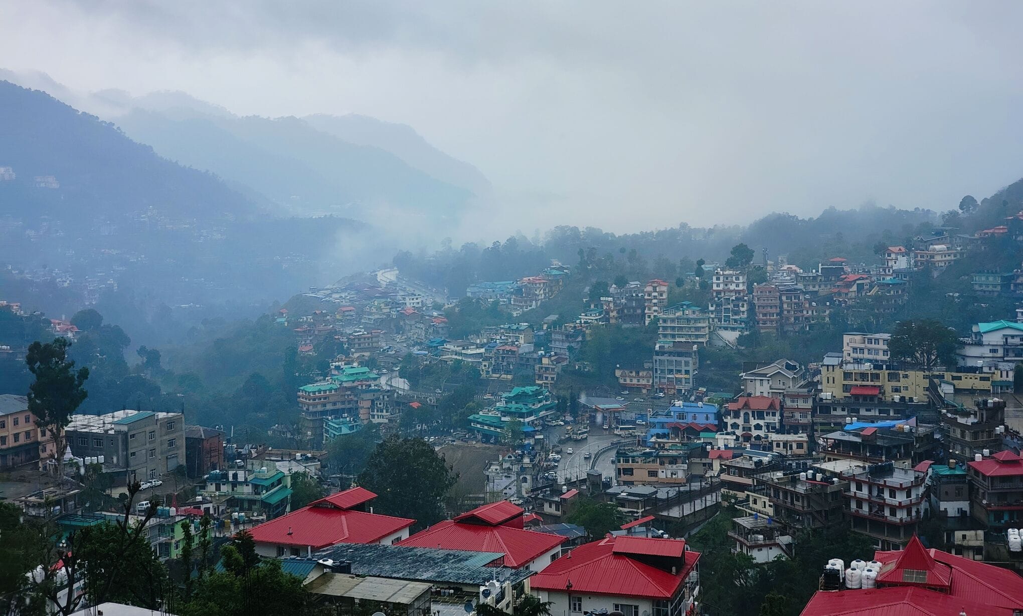 सोलन शहर के मालरोड पर बारिशमें छाता लेकर घूमते लोग। संवाद