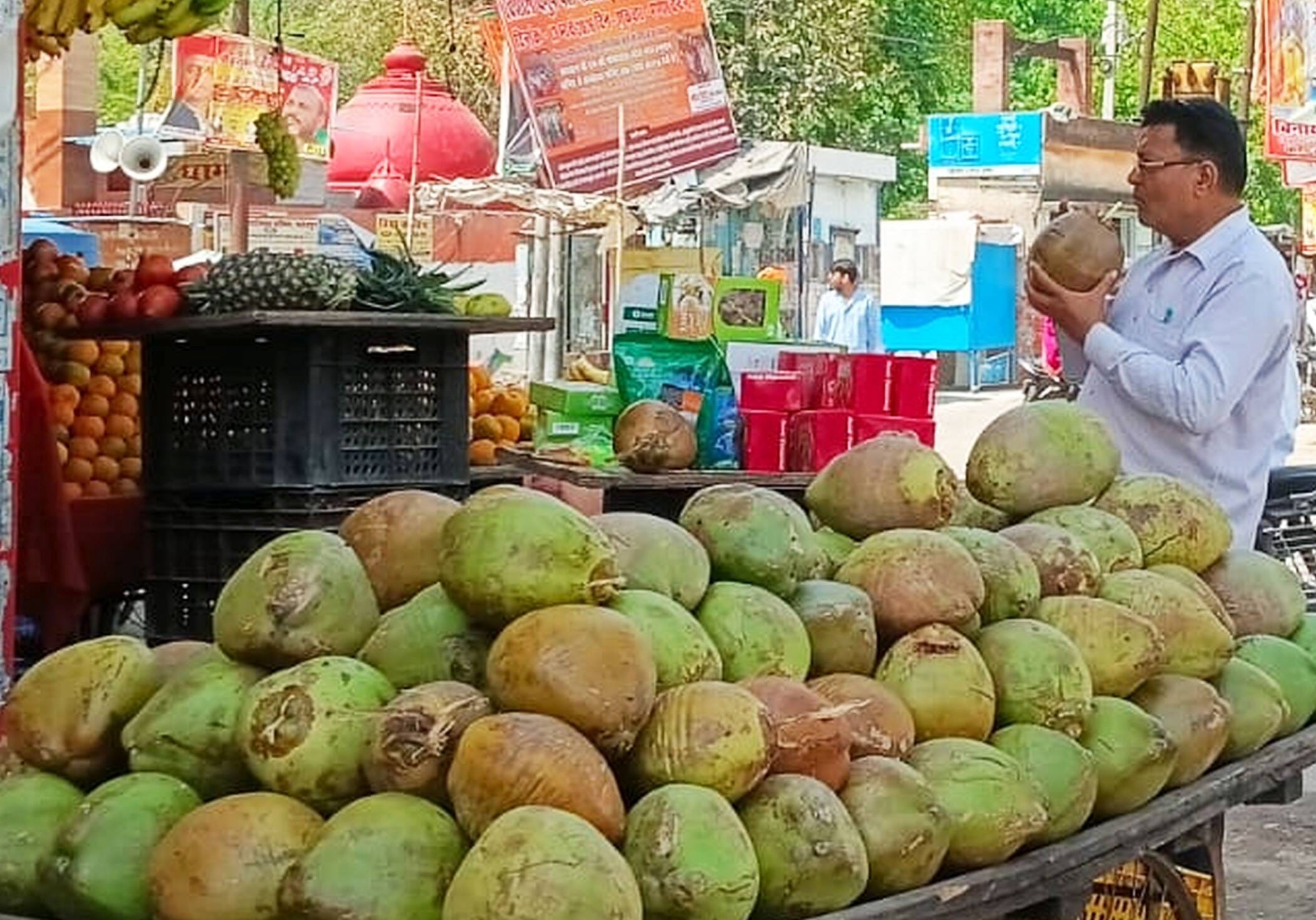 फोटो-12-पटेल नगर चौराहा स्थित दुकान में नारियल पीता युवक। संवाद