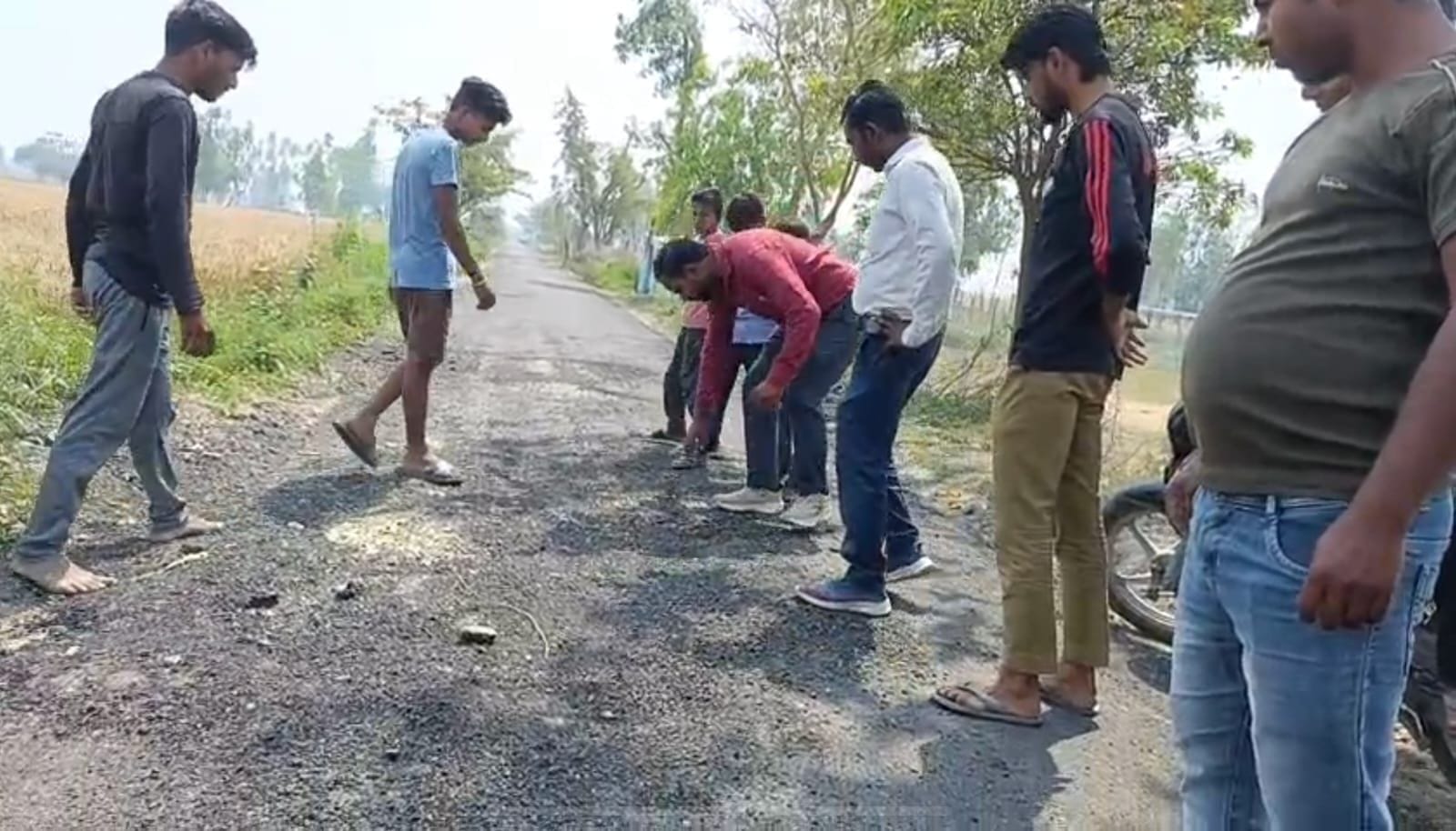 उखड़ी सड़क दिखाते ग्रामीण। उखड़ी सड़क दिखाते ग्रामीण।
