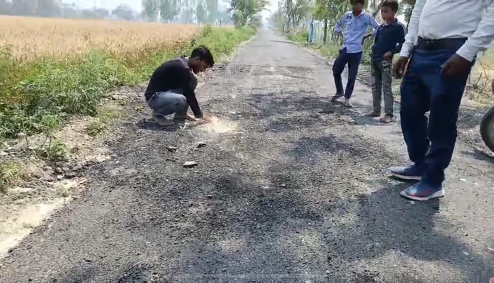 उखड़ी सड़क दिखाते ग्रामीण। उखड़ी सड़क दिखाते ग्रामीण।