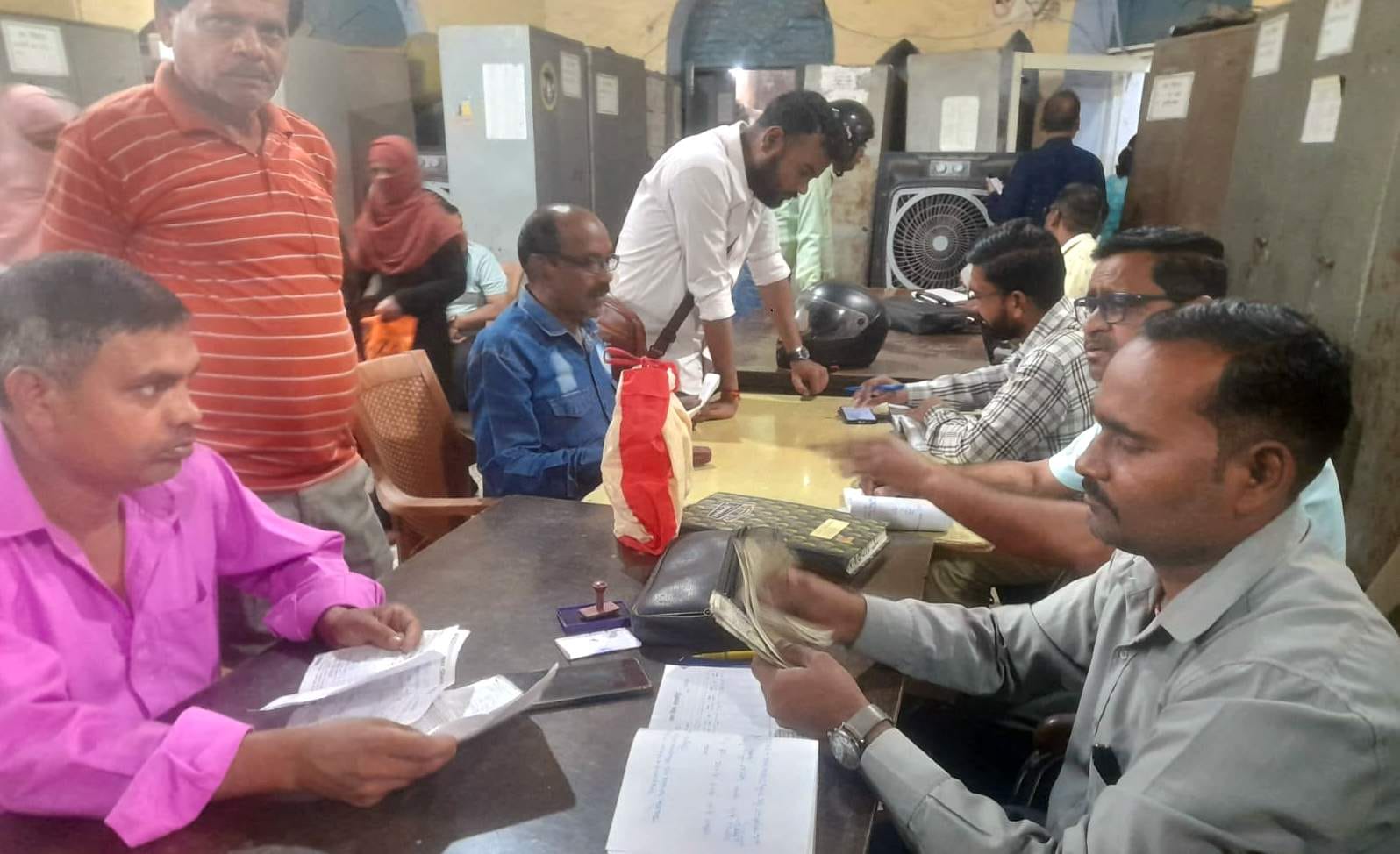 कलक्ट्रेट स्थित जिला कोषागार कार्यालय में कार्य करते अधिकारी और कर्मचारी। संवाद