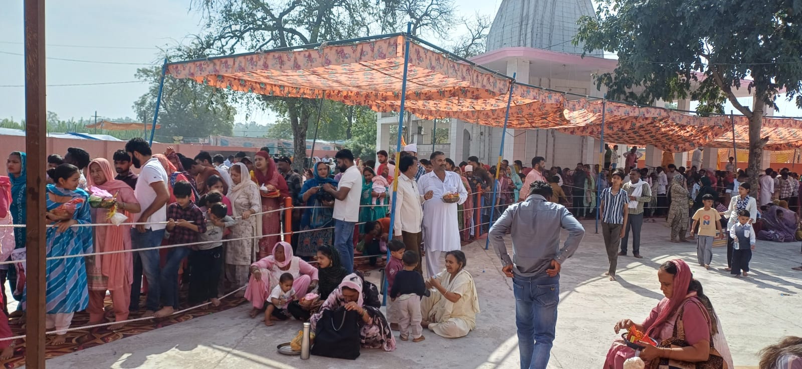 गांव सारन में आयोजित मेले में माथा टेकने के लिए कतार में खड़े श्रद्धालु। संवाद