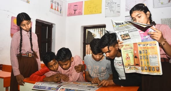 स्कूलों में अखबार पढ़ते बच्चे। स्कूलों में अखबार पढ़ते बच्चे।
