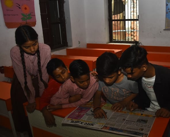 स्कूलों में अखबार पढ़ते बच्चे। स्कूलों में अखबार पढ़ते बच्चे।