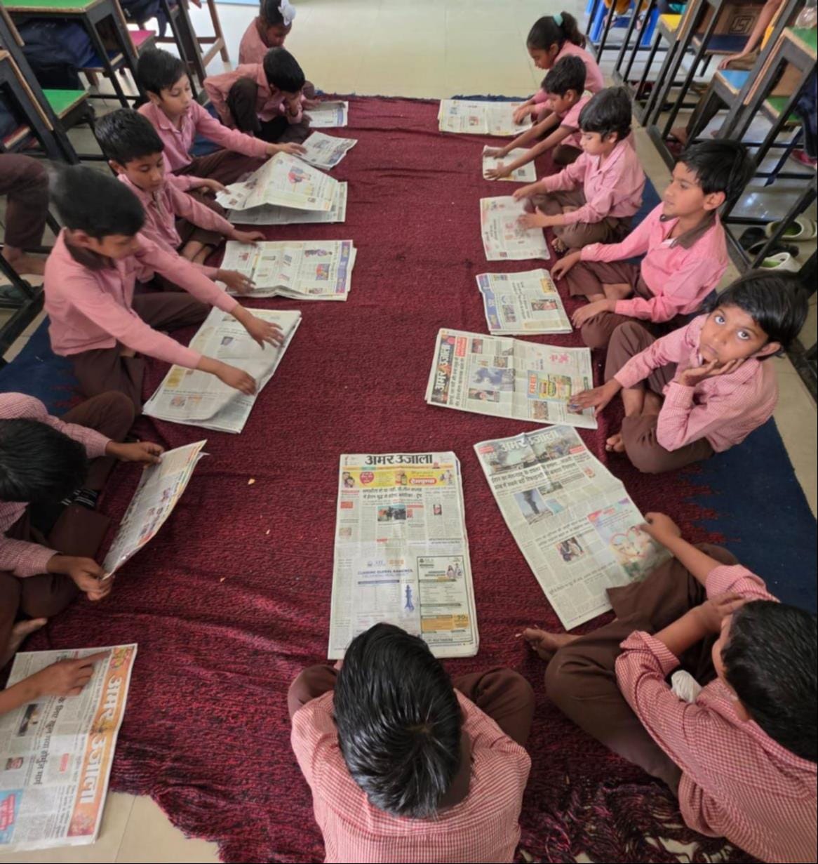 ऊन प्राथमिक स्कूल में अखबार पढ़ते छात्र । स्कूल