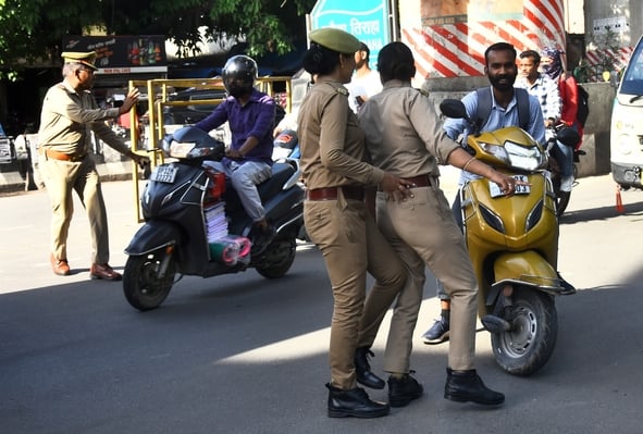 वाहन चेकिंग अभियान में नियम तोड़ने वालों पर कार्रवाई करते पुलिसकर्मी