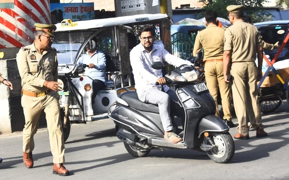 वाहन चेकिंग अभियान में नियम तोड़ने वालों पर कार्रवाई करते पुलिसकर्मी
