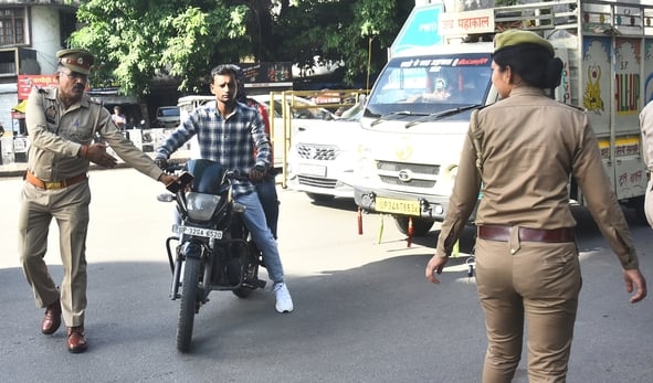 वाहन चेकिंग अभियान में नियम तोड़ने वालों पर कार्रवाई करते पुलिसकर्मी